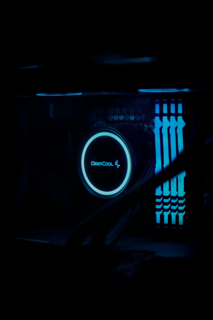 Close-up of a futuristic gaming PC with LED lights and water cooling system in a dark setting.