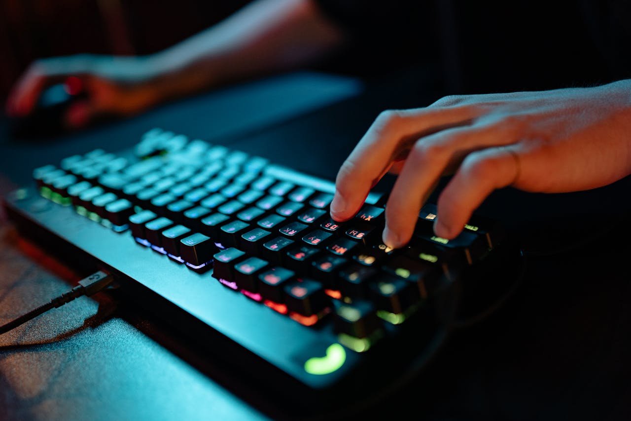 Crafting Captivating Headlines: Your awesome post title goes here Hands typing on a glowing RGB keyboard during a gaming session indoors.